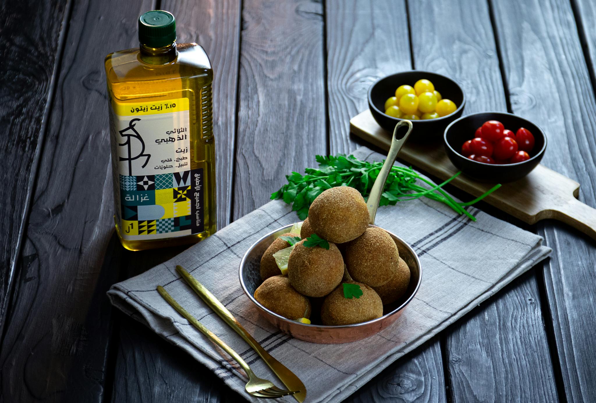 A rustic Tunisian food setup featuring olive oil and vegetable dishes on a wooden table.